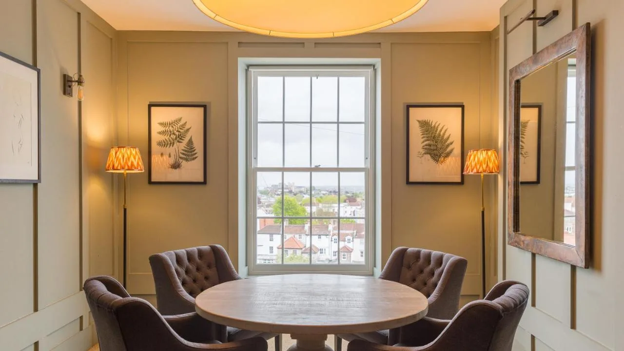 a table and chairs in a room with a window at Number 38 Clifton in Bristol